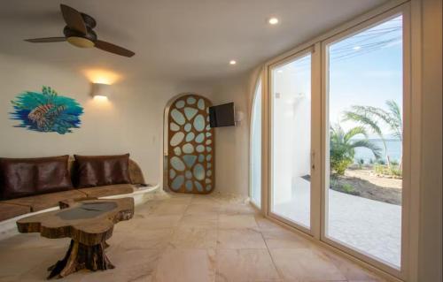 a living room with a couch and a table at Alterhome Swan villas with swimming pool and ocean views in Placencia Village