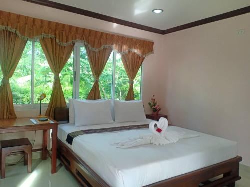 a bedroom with a white bed with a window at Capital O 75415 Nanthachart Riverview Resort in Samut Songkhram