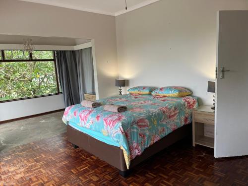 una camera con un grande letto e una finestra di 10 st Johns - House a Port Shepstone