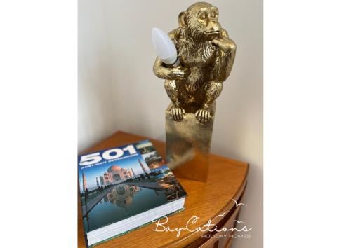 a statue of a monkey holding a candle on a table at Stylish 2 bed Paignton apartment, 5 minute walk to beach in Paignton