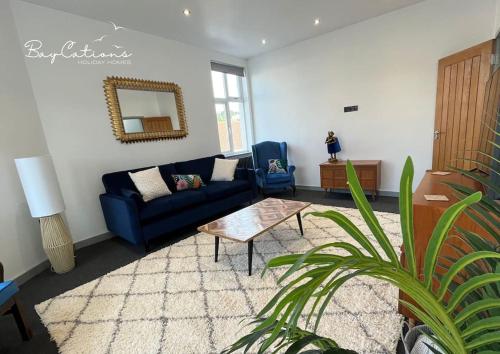 - un salon avec un canapé bleu et une table dans l'établissement Stylish 2 bed Paignton apartment, 5 minute walk to beach, à Paignton
