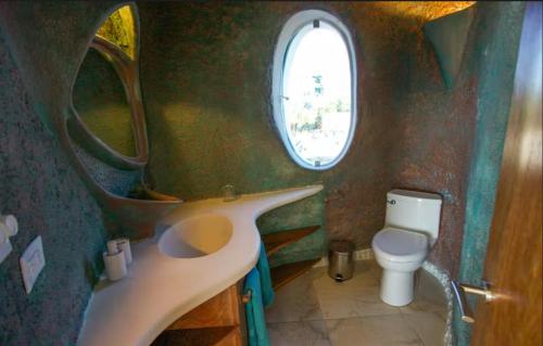 a small bathroom with a sink and a toilet at Alterhome Swan villas with swimming pool and ocean views in Placencia Village