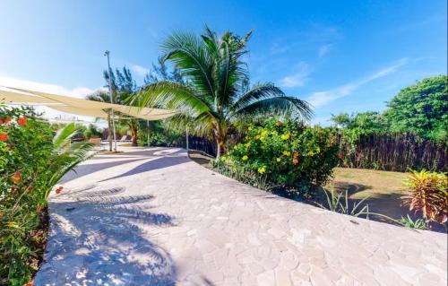 a walkway with a umbrella and some plants and trees at Alterhome Swan villas with swimming pool and ocean views in Placencia Village