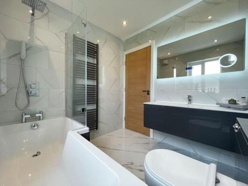 a bathroom with a tub and a toilet and a sink at Luxury 7 Bedroom House in Didsbury, Manchester in Manchester