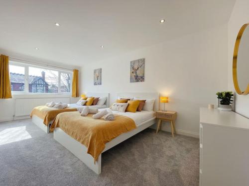 a white bedroom with a large bed and a window at Luxury 7 Bedroom House in Didsbury, Manchester in Manchester