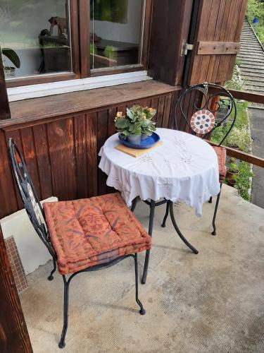 un tavolo e sedie su un portico con una pianta di Chez Ninfa a Villeret