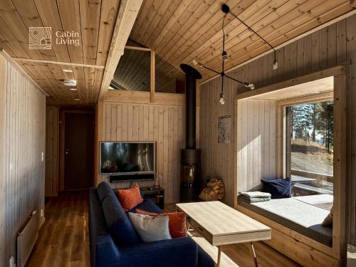 a living room with a couch and a table at Modern New Large Cabin Ski in out Sjusjøen in Ringsaker