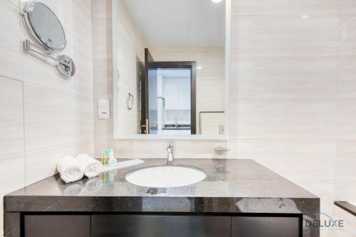 a bathroom with a sink and a mirror at Peaceful Studio at Celestia A Dubai South by Deluxe Holiday Homes in Dubai
