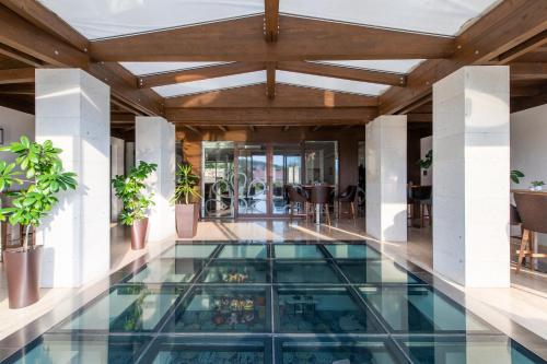 an indoor pool with a glass floor in a building at Botrytis Borhotel in Mád