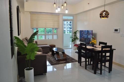 uma sala de estar com uma mesa e uma sala de jantar em Twinlakes Condominium Tagaytay, LL1R Shiraz em Tagaytay