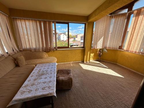 a living room with a couch and some windows at Hotel Rade 2 in Vratsa