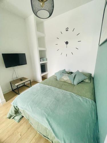 une chambre avec un lit et une horloge au mur dans l'établissement Superbe studio moderne chic, à Saint-Juéry-les-Azalate