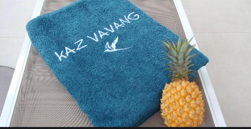 un ananas sur une serviette bleue avec les mots karma dans l'établissement Kaz Vavang magnifique villa 4 ETOILES, à Étang-Salé les Bains