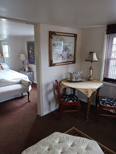 a hotel room with a bed and a table and chairs at The guest house at the regina house tea room in Moosic