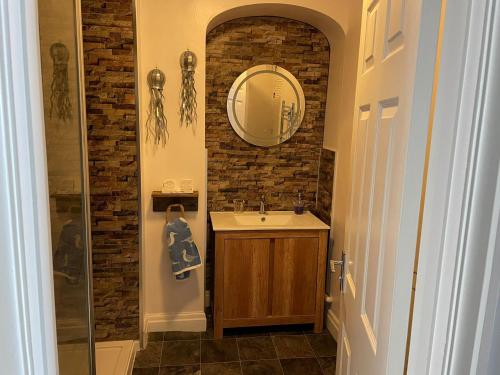 a bathroom with a sink and a mirror at Newton Croft Tenby overlooking North Beach in Tenby