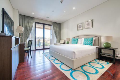 a bedroom with a large bed and a living room at Paradise 2BR at Royal Amwaj North Palm Jumeirah by Deluxe Holiday Homes in Dubai