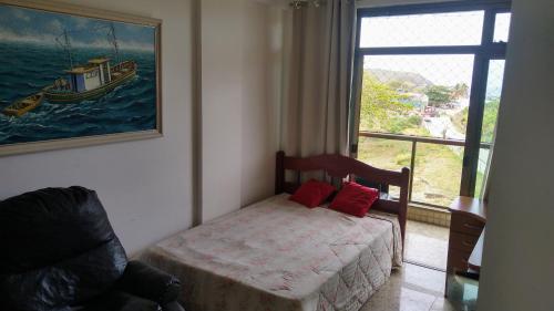 Un dormitorio con una cama y una ventana con un barco en De frente pro mar em Cabo Frio, en Cabo Frío