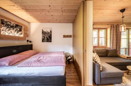 a bedroom with a bed and a couch at Alpin Chalet Schröcken in Schröcken