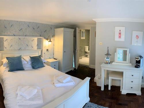a bedroom with a large white bed and a bathroom at Ferryman`s Cottage at The Beetle & Wedge in Moulsford