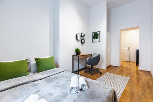 1 dormitorio con cama, escritorio y silla en Stylish designed apartment in a calm district en Viena