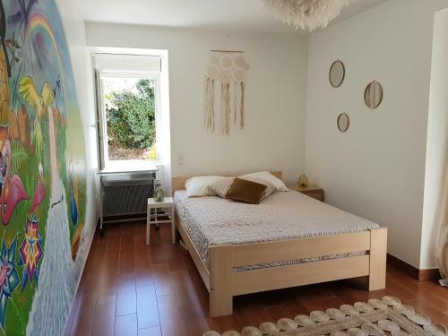 une chambre avec un lit et un tableau au mur dans l'établissement Aux Chambres du Chadoux de Chateaubourg (ChaChaCha), à Châteaubourg