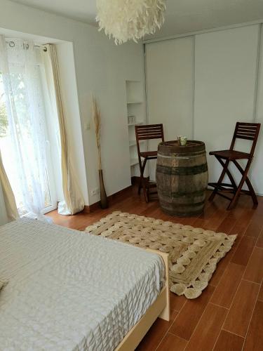- une chambre avec un lit, un tonneau et des chaises dans l'établissement Aux Chambres du Chadoux de Chateaubourg (ChaChaCha), à Châteaubourg