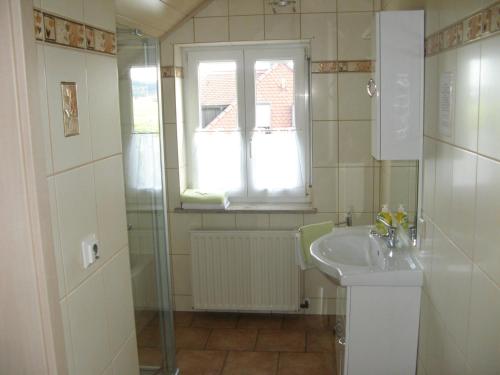 a bathroom with a sink and a window at Pension Wolkenstein in Langenbruck