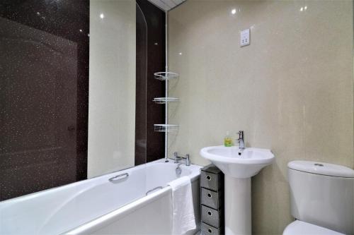 a bathroom with a tub and a sink and a toilet at Signature - Kirkhill Middle in Kirkmuirhill