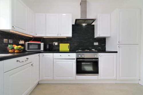 KirkmuirhillにあるSignature - Kirkhill Middleの白いキッチン(白いキャビネット、電子レンジ付)