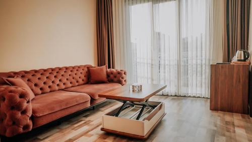 a living room with a brown couch and a table at The Grand Mira Business Hotel in Istanbul