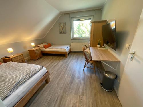 a small room with a bed and a desk with a television at Hotel St. Peter in Dormagen