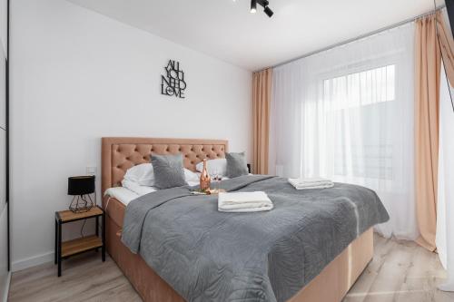 Un dormitorio con una cama grande y una ventana en Apartments Nad Parsętą Młyńska by Renters en Kołobrzeg