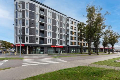 a large building on a street with a crosswalk at Apartments Nad Parsętą Młyńska by Renters in Kołobrzeg