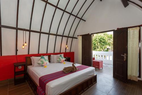 1 dormitorio con 1 cama en una habitación en Kidi's Lodge Gilitrawangan, en Gili Trawangan