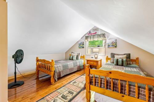 a attic bedroom with two beds and a window at Grandfather's Gem Getaway in Banner Elk