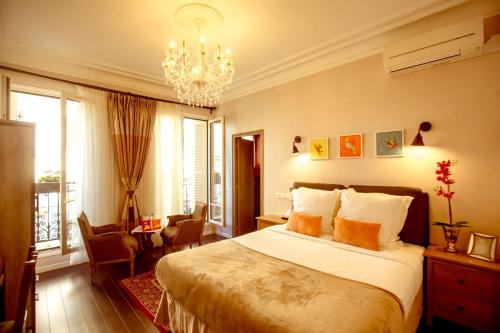 パリにあるLa Maison Gobert Paris Hotel Particulierのベッドルーム1室(大型ベッド1台、シャンデリア付)