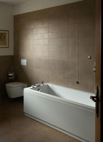 a bathroom with a white tub and a toilet at La tua villa sul Lago - Casa Kollegger in Luino