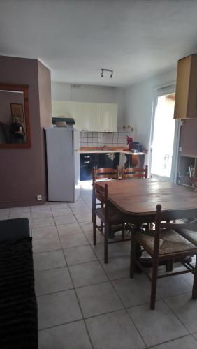 a kitchen with a table and chairs and a kitchen with a refrigerator at 50 M OCÉAN maison classée 2 étoiles 2/7 personnes in Mimizan