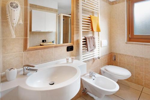 een badkamer met een witte wastafel en een toilet bij Baita Aris Appartamento Ables in Livigno