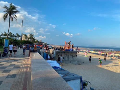 a group of people walking on the beach at Hotel Nắng in Vung Tau