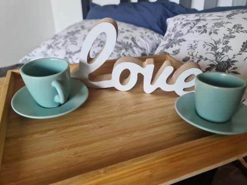 a table with two cups and a sign that reads love at STUDIO 33 in Šabac