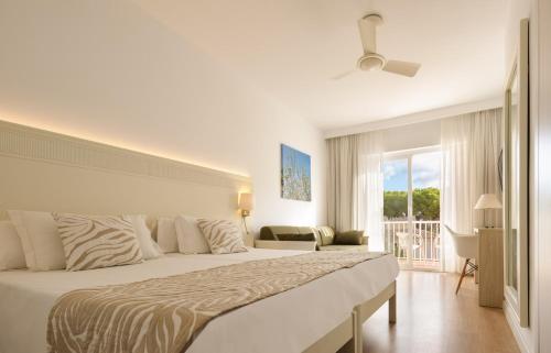 Un dormitorio con una cama grande y un balcón. en Hotel Castell dels Hams, en Porto Cristo