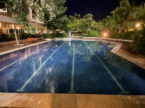 een groot zwembad in de nacht bij ReLuxe マリン Condo in Maribago