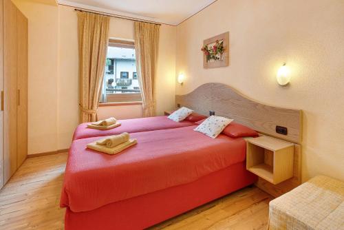 ein Hotelzimmer mit einem roten Bett und einem Fenster in der Unterkunft Baita Aris Appartamento Canton in Livigno