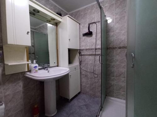 a bathroom with a sink and a shower at Center Appartment in Tirana