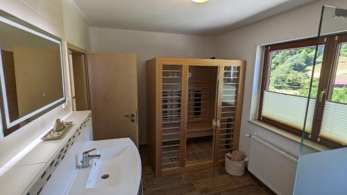 a bathroom with a sink and a toilet and a window at Hof Helmenhube 1 in Gammelsbach