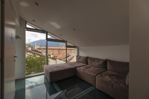 sala de estar con sofá y suelo de cristal en HEART OF TRENTO Loft & Rooms, en Trento