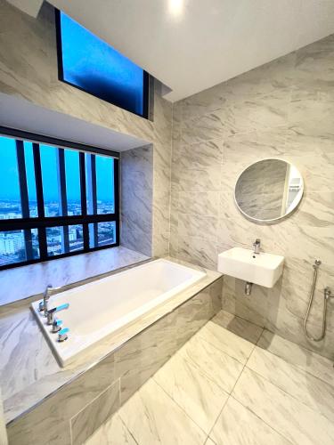 a bathroom with a tub and a sink and a window at Imperio Residences Private Bathtub or Jacuzzi by Nestcove in Melaka