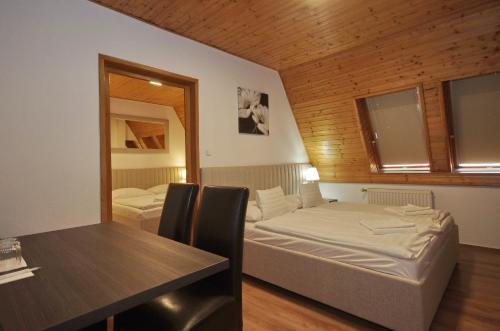 1 dormitorio con cama, mesa y espejo en Aqua Hotel en Gyula