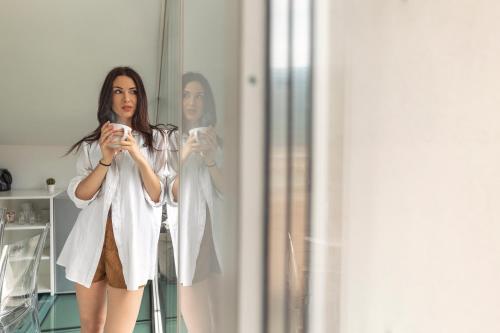 una mujer tomando una foto de sí misma en un espejo en HEART OF TRENTO Loft & Rooms, en Trento
